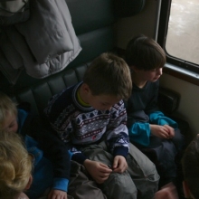 Vlak byl docela slušně obsazen; zde vidíme tři cestující na dvou sedačkách. 