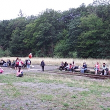 Z nedostatku laviček si lidi čekající na vlak odpoledne posedali, kde se dalo. 
